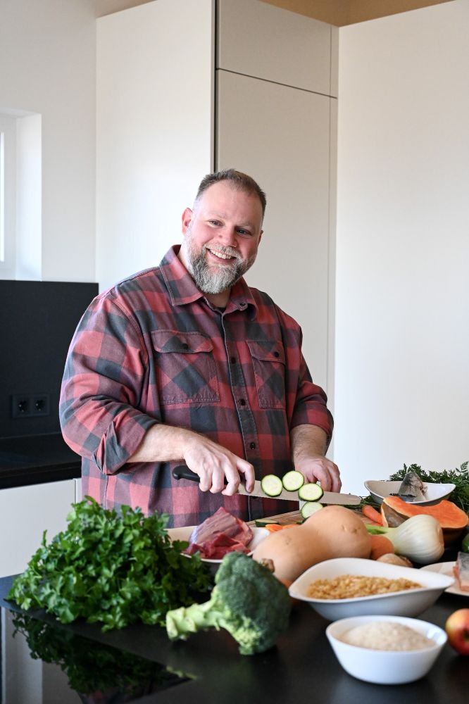 Patrick Welz - Ernährungsberater für Hunde - Kahu Ono steht in der Küche und schneidet Gemüse